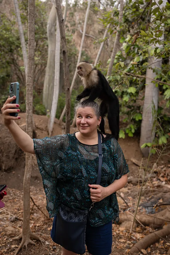 A guest taking a selfie with a capuchin monkey near Playa Caldera, Costa Rica